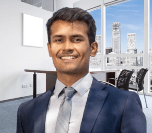 Portrait of Asad Ahmad, co-founder and CPA at FitBiz CPA, a professional accounting firm. Asad is shown standing confidently in front of a modern office setting, wearing a professional suit and a friendly smile. He appears to be a trustworthy and knowledgeable advisor who is passionate about helping business owners achieve their financial goals.
